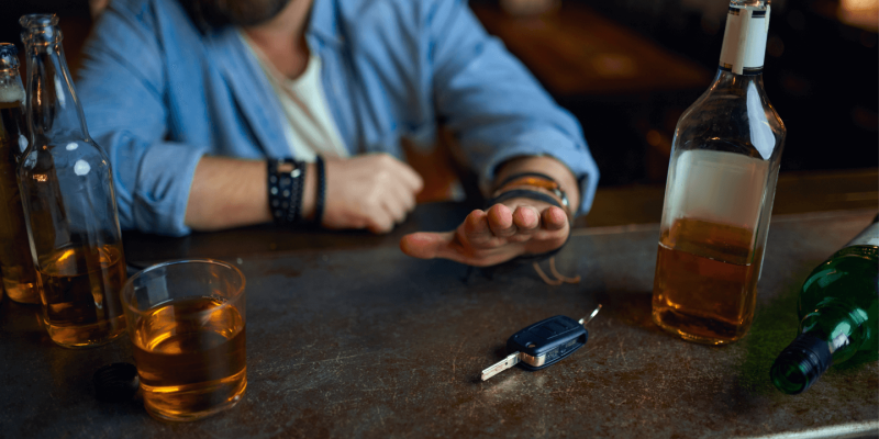 person at bar with alcohol and car keys