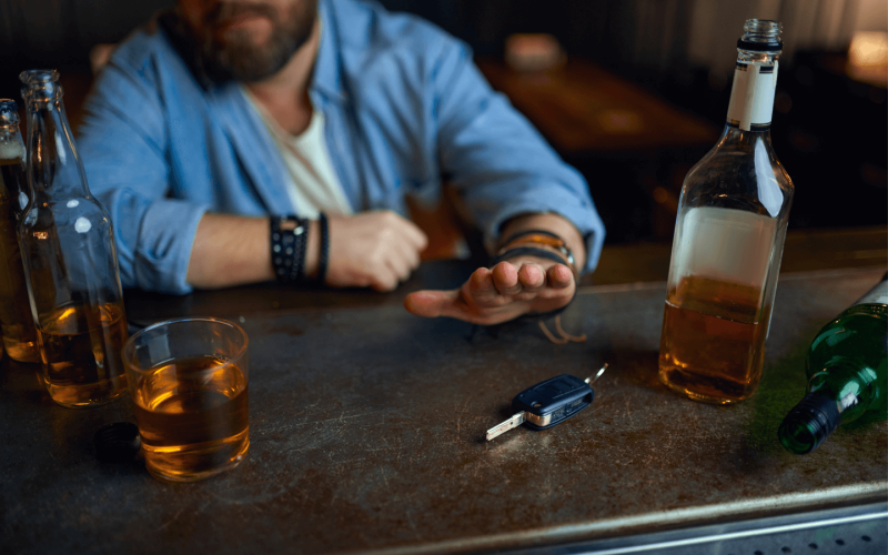 person at bar with alcohol and car keys